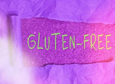 Kelime yazma metni Gluten Free. Buğday ununun inatçı elastik protein maddesini içermeyen iş konsepti. Klasik ahşap bir masa arkaplanının üzerine yerleştirilmiş parçalanmış karton..