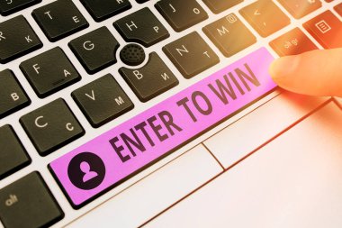 Enter To Win 'i gösteren kavramsal el yazısı. Boş arkaplanda aksesuarlarla birlikte Renkli PC klavye anahtarı kazanma şansı ya da ödülü için bir şey değiş tokuş eden iş fotoğrafı gösterimi.