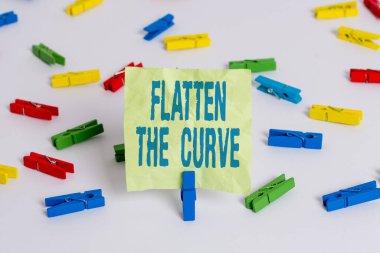 Eğriyi Düzleştir 'i gösteren not yazılıyor. İş fotoğrafı gösterimi, bulaşıcı hastalığın hızı hakkında farkındalığı artırıyor. Renkli çamaşır iğnesi kağıtları boş hatırlatıcı beyaz zemin arka planı