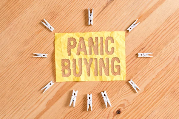 Panik Satın Almayı gösteren bir not yazıyorum. İş fotoğraflarının sergilenmesi, ani bir kıtlık korkusuyla büyük miktarlarda mal alıyor. Renkli çamaşır iğnesi kağıtları boş ahşap zemin ofisini hatırlatıyor..