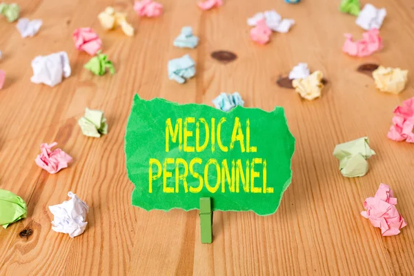 Word writing text Medical Personnel. Business concept for trusted healthcare service provider allowed to treat illness Colored crumpled papers empty reminder wooden floor background clothespin.