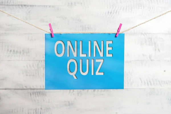 Handwriting text Online Quiz. Concept meaning game or a mind sport that are published on the Internet Clothesline clothespin rectangle shaped paper reminder white wood desk.