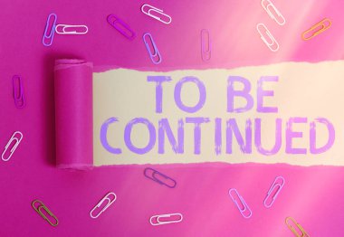 Devam Edilmesi Gerektiğini gösteren kavramsal el yazısı. İş fotoğrafı metni, hikayenin bir sonraki bölümde devam ettiğini gösteriyor. Yırtılmış karton, ahşap klasik bir masanın üstünde..