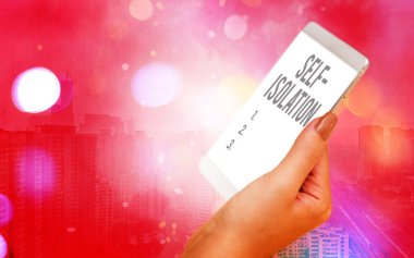 Kelime yazma metni Kendini İzolasyon. Renkli bokeh arkaplan altında beyaz ekranlı modern cihazlarla temastan kaçınarak enfeksiyon kontrolünü destekleme konsepti.