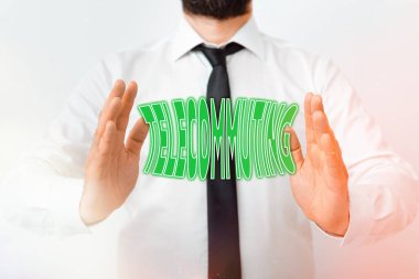 Telekomünikasyonu gösteren bir not yazıyorum. Merkezi ofis modeliyle elektronik bağlantı kurarak evde iş fotoğraflarının sergilenmesi, yön bulma sürecinin büyümesini sembolize ediyor..