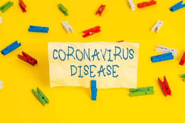 Записка о коронавирусной болезни. Деловая фотовыставка, определяемая как болезнь, вызванная новым вирусом SARSCoV2 Цветные бумаги для белья пустое напоминание желтый пол фоновый офис. — стоковое фото