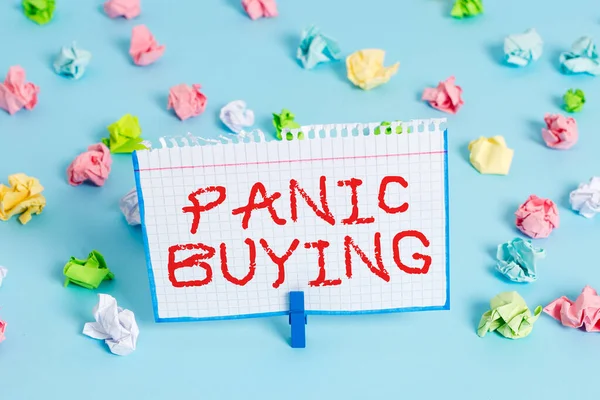 El yazısı Panik Satın Alma. Kavram demek, ani kıtlık korkusuyla büyük miktarlarda mal almak demek. Renkli buruşuk kağıtlar boş mavi zemin çamaşır mandalı..