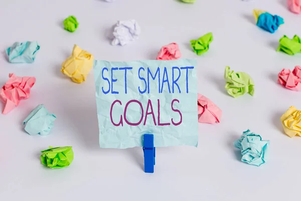 Kézírás szöveg Beállítás Smart Goals. Koncepció jelentése, amely kritériumok útmutató a célok meghatározása Színes gyűrött papírok üres emlékeztető fehér padló háttér ruhaszárító. — Stock Fotó