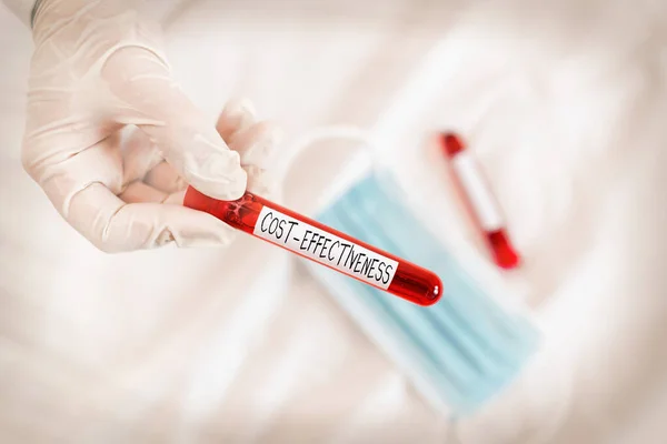 Text sign showing Cost Effectiveness. Conceptual photo degree to which something is effective in relation to its cost. Extracted blood sample vial ready for medical diagnostic examination.
