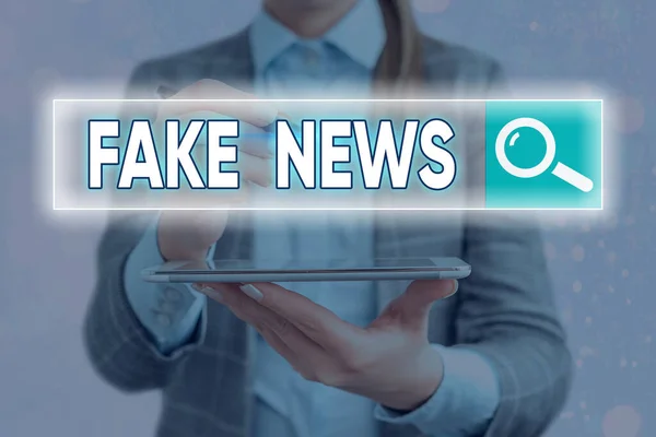 Handwriting text writing Fake News. Concept meaning false information publish under the guise of being authentic news Web search digital information futuristic technology network connection.