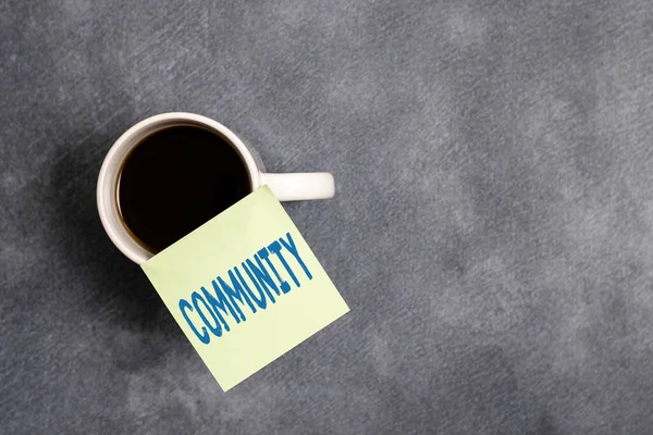 Tekst schrijven Gemeenschap. Zakelijk concept voor groep van tonen met een gemeenschappelijke kenmerken samenleven Papieren accessoires met digitale smartphone gerangschikt op verschillende achtergrond. — Stockfoto