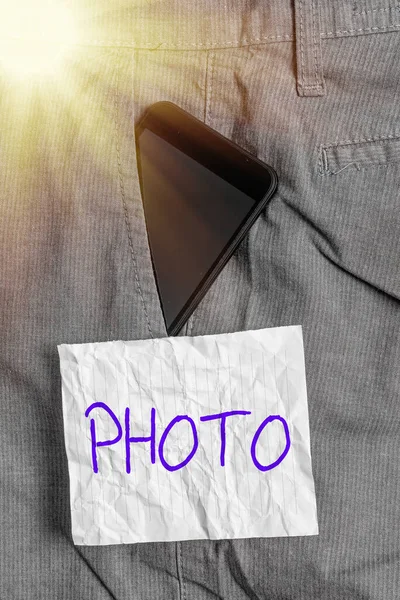 Textskylt med foto. Begreppsbild definieras som producerad av ljus, bild tagen med hjälp av ljus. Smartphone enhet inuti formella arbetsbyxor framficka nära anteckning papper. — Stockfoto
