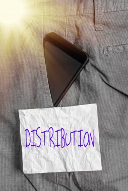 Dağıtımı gösteren metin işareti. Resmi iş pantolonu içindeki bir alan üzerinde oluşumun kavramsal fotoğraf konumu, düzenleme veya sıklığı not kağıdının yanındaki ön cebin içindeki akıllı telefon aygıtı.