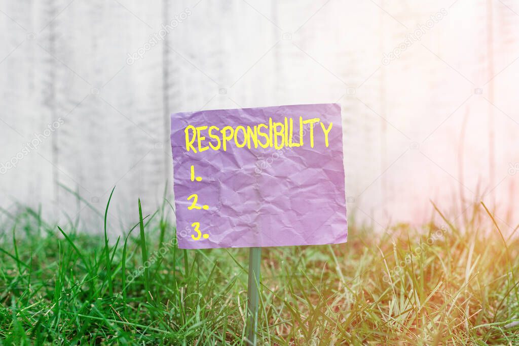Conceptual hand writing showing Responsibility. Business photo text state of being responsible, something for one is responsible Plain paper attached to stick and placed in the grassy land.