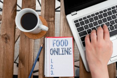 Yemek İnternetini gösteren kavramsal el yazısı. İş fotoğrafı gösterimi, kişisel ilgi için kullanılan dizüstü bilgisayarla telefon uygulaması ya da web sitesi iş yeri genel görünümü kullanarak bir şeyler yemek istiyor.