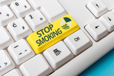 Sigara içmeyi bıraktığını gösteren kavramsal el yazısı. Ticari fotoğraf metninin tütün bağımlılığını durdurması veya durdurması Boş arkaplanda aksesuarları olan renkli PC klavye anahtarı.