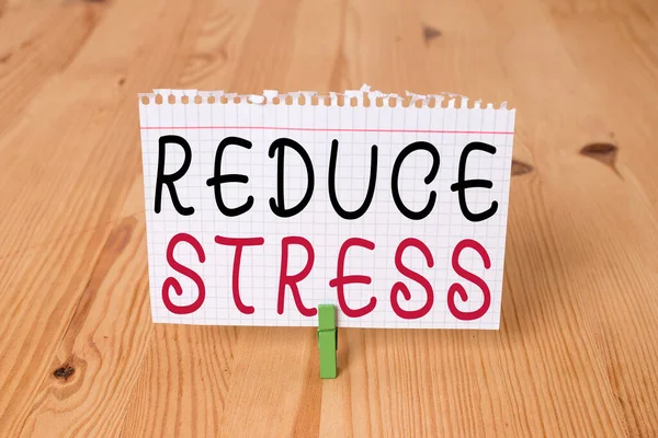 Word writing text Reduce Stress. Business concept for to lessen the state of mental or emotional strain or tension Empty reminder wooden floor background green clothespin groove slot office.