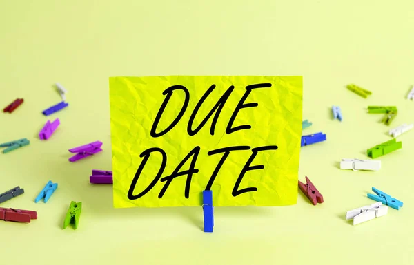 Text sign showing Due Date. Conceptual photo the day or date by which something is supposed to be done or paid Colored crumpled rectangle shaped reminder paper light blue background.