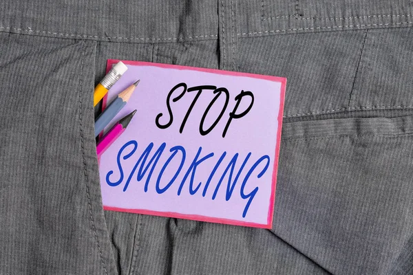 Text ukazující Stop kouření. Konceptuální foto proces ukončení nebo ukončení kouření tabáku Vybavení pro psaní a fialový poznámkový papír v kapse pracovních kalhot. — Stock fotografie