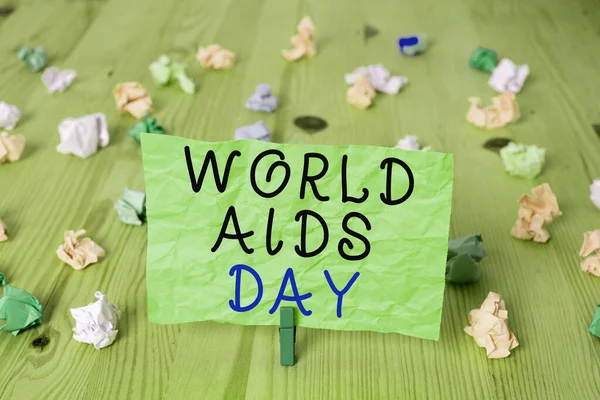 Woordschrijvende tekst World Aids Day. Business concept voor een internationale dag om het bewustzijn van de AIDS-pandemie te verhogen Gekleurde verfrommelde rechthoekige herinneringsdocument lichtblauwe achtergrond. — Stockfoto
