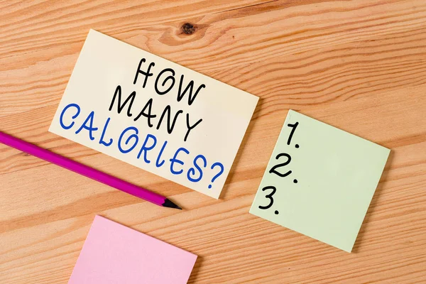 Text sign showing How Many Calories Question. Conceptual photo asking how much energy our body could get from it Colored clothespin papers empty reminder wooden floor background office.