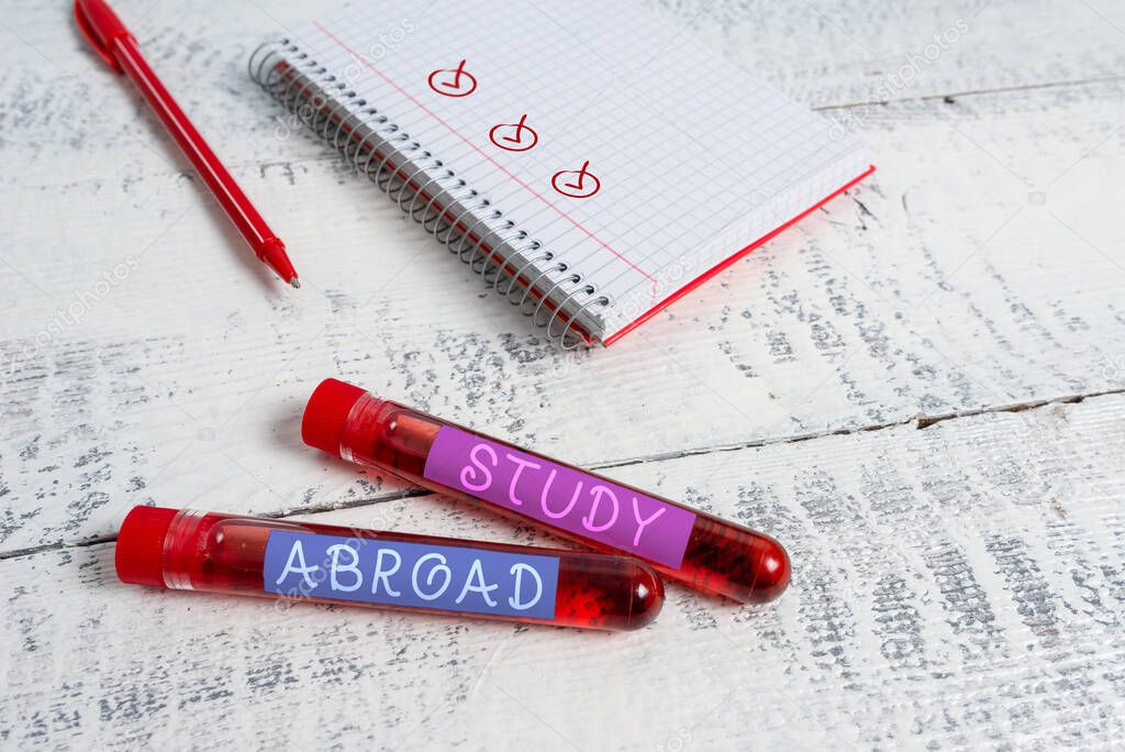 Handwriting text Study Abroad. Concept meaning Pursuing educational opportunities in a foreign country Extracted blood sample vial with medical accessories ready for examination.
