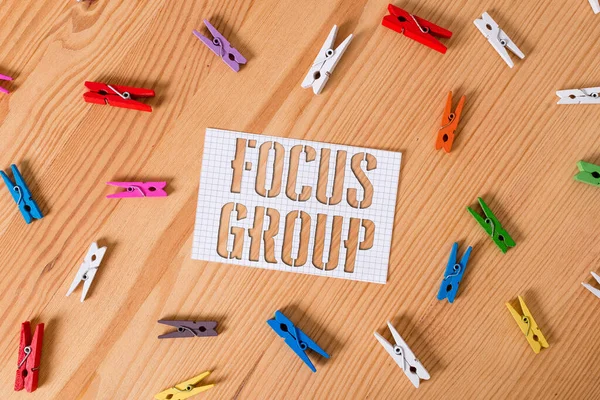 Handwriting text writing Focus Group. Concept meaning showing assembled to participate in discussion about something Colored clothespin papers empty reminder wooden floor background office. — Stock Photo, Image