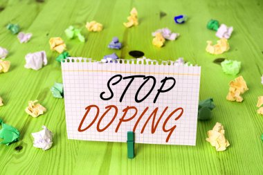 Dopingin durduğunu gösteren kavramsal el yazısı. İş fotoğrafı metni yasaklanmış atletik performans artırıcı ilaçların kullanımını bıraktı. Kırışmış dikdörtgen şekilli kağıt açık mavi arka plan.