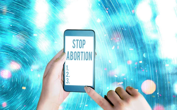 Manuscrito texto escrito Stop Abortion. Conceito significado defendendo contra a prática do aborto Movimento Prolife gadgets modernos com tela de exibição branca sob fundo bokeh colorido. — Fotografia de Stock