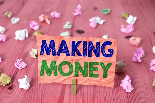 Writing note showing Making Money. Business photo showcasing Giving the opportunity to make a profit Earn financial support Colored crumpled rectangle shaped reminder paper light blue background.