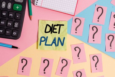 Diyet Planı 'nı gösteren metin işareti. Belirli bir ağırlık elde etmek için konseptsel fotoğraf miktarı planlanmaktadır. Matematiksel şeyler ve yazma ekipmanları pastel renklerin üzerinde.