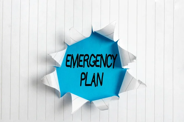Writing note showing Emergency Plan. Business photo showcasing actions to be conducted in a certain order or manner Rolled ripped torn cardboard above a wooden classic table. — Stock Photo, Image