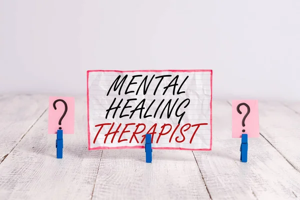 Handwriting text Mental Healing Therapist. Concept meaning helping an individual express emotions in healthy ways Scribbled and crumbling sheet with paper clips placed on the wooden table.