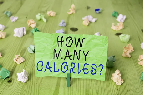 Woord schrijven tekst Hoeveel calorieën vragen. Zakelijk concept voor het vragen hoeveel energie ons lichaam zou kunnen krijgen van het Gekleurde verfrommelde rechthoek vormige herinnering papier lichtblauwe achtergrond. — Stockfoto