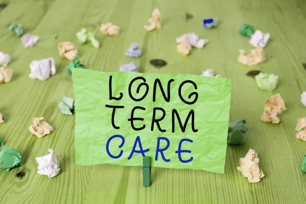 Word σύνταξη κειμένου Long Term Care. Επιχειρηματική ιδέα για βοήθεια με τα βασικά ατομικά καθήκοντα της καθημερινής ζωής Έγχρωμο τσαλακωμένο ορθογώνιο σχήμα υπενθύμισης χαρτί ανοιχτό μπλε φόντο. — Φωτογραφία Αρχείου