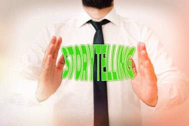 Hikaye anlatımını gösteren bir not yazıyorum. Anekdotların iş fotoğraflarının gösterimi, hikayelerin okuyucusu, hikayelerin yazarı. Navigasyon gelişimini sembolize eden el hareketleriyle model al..