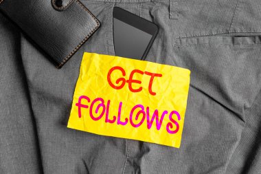 Get Follows 'u gösteren bir not yazıyorum. Kopyalarını taklit eden ya da örnek alan birini gösteren bir iş fotoğrafı. Pantolonun ön cebinde cüzdanı olan özel bir akıllı telefon cihazı..