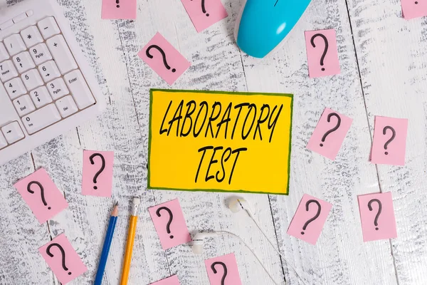 Text sign showing Laboratory Test. Conceptual photo Determination of a medical diagnosis from the substances tested Writing tools, computer stuff and scribbled paper on top of wooden table.