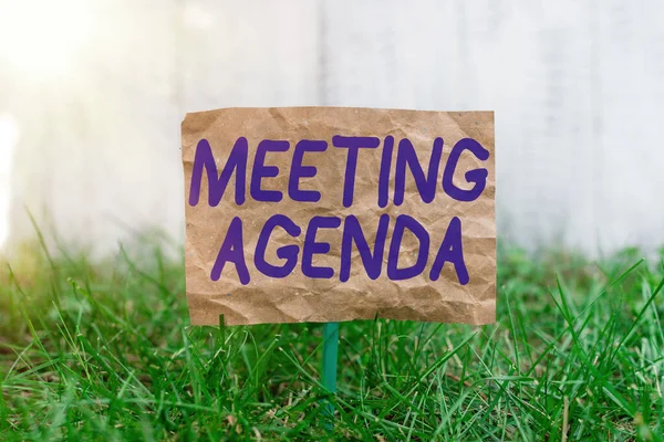 Word writing text Meeting Agenda. Geschäftskonzept für Gegenstände, die die Teilnehmer bei einem Treffen zu erreichen hoffen, zerknülltes Papier an einem Stock befestigt und in der grünen Wiese platziert. — Stockfoto