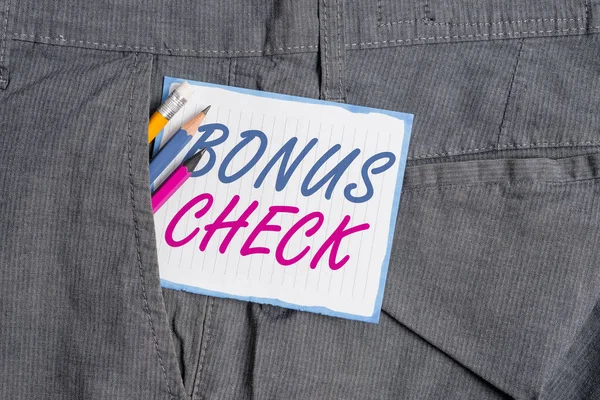 Handwriting text Bonus Check. Concept meaning something in addition to what is expected or strictly due Writing equipment and white note paper inside pocket of man work trousers.