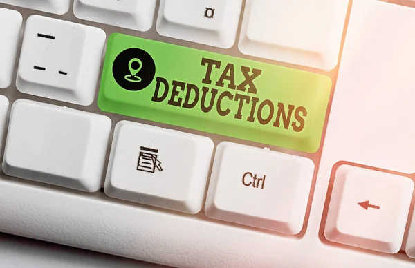 Text sign showing Tax Deductions. Conceptual photo an amount or cost that subtracted from someone s is income Different colored keyboard key with accessories arranged on empty copy space. — Stock Photo, Image