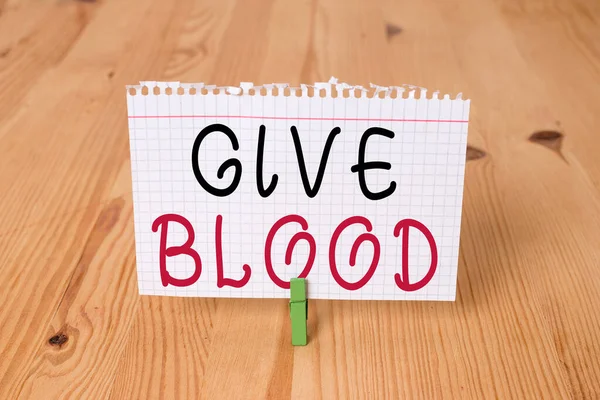 Palavra escrita texto Dê sangue. Conceito de negócio para um indivíduo voluntariamente tem sangue extraído e usado para transfusões Lembrete vazio piso de madeira fundo verde clothespin groove slot office. — Fotografia de Stock