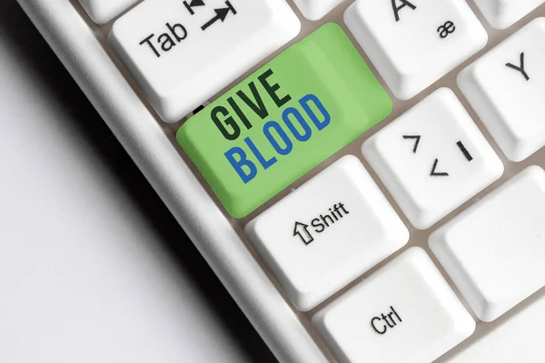 A escrever um bilhete a mostrar Give Blood. Foto de negócios mostrando um indivíduo voluntariamente tem sangue extraído e usado para transfusões Tecla de teclado colorida com acessórios dispostos em espaço de cópia vazio. — Fotografia de Stock