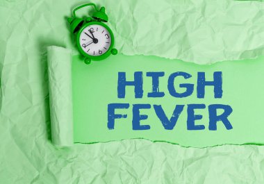 SMS işareti yüksek ateşi gösteriyor. Vücut sıcaklığının normalden daha yüksek olduğu kavramsal fotomedikal durum. Yırtılmış karton, ahşap bir masa arkaplanının üzerine yerleştirilmiş..