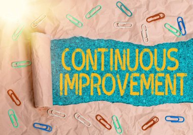 Sürekli Gelişme gösteren bir not yazıyorum. Ürün ve süreçleri geliştirmek için devam eden fotoğraf sergileniyor. Tahta klasik bir masanın üzerinde parçalanmış karton rulo..