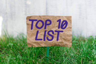 Kelime yazma metni Top 10 listesi. Belirli bir listedeki en önemli ve en başarılı on parça için iş konsepti bir çubuğa yapıştırılmış buruşuk kağıt ve yeşil çimenli araziye yerleştirildi.