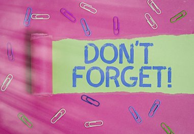 Don 't Forget' u gösteren kavramsal el yazısı. İş fotoğrafı metni, birine önemli bir gerçeği veya detayı hatırlatmak için kullanılır. Yırtılmış karton, ahşap klasik bir masanın üstünde..