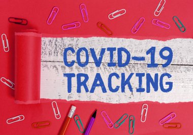 Covid 19 'un izini sürdüğünü gösteren bir not yazıyorum. Enfeksiyon kapmış olabileceklerin ayırt edici özelliklerini gösteren bir iş fotoğrafı. Tahta klasik bir masanın üzerinde yırtılmış karton kaplama..