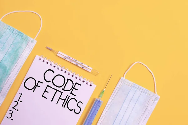 Handwriting text Code Of Ethics. Concept meaning basic guide for professional conduct and imposes duties Set of medical equipment with notepad for health condition assessment.