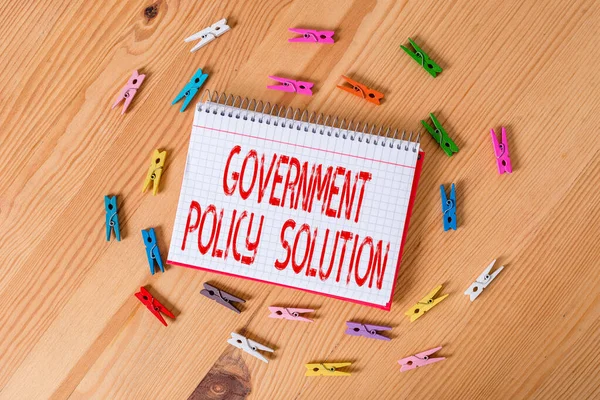 Handschrift tekst schrijven Government Policy Solution. Concept betekent ontworpen game plan gemaakt in reactie op noodsituatie ramp Kleurrijke wasknijpers lege herinnering houten vloer achtergrond — Stockfoto